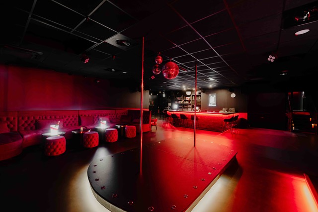 Piste avec barre de pole dance dans le club libertin Bada Club