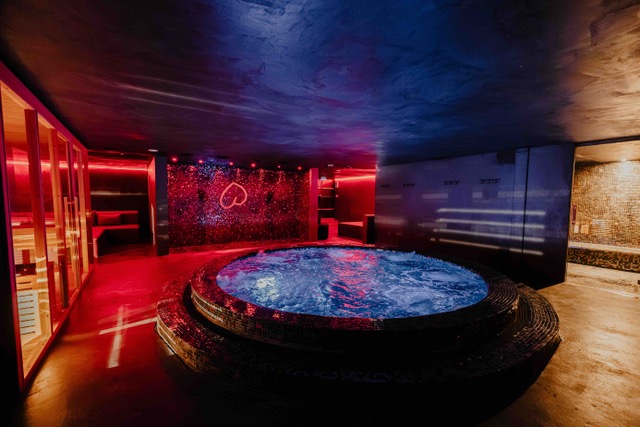 Jacuzzi et sauna du Bada Club à Dardilly, ambiance rouge et bleue
